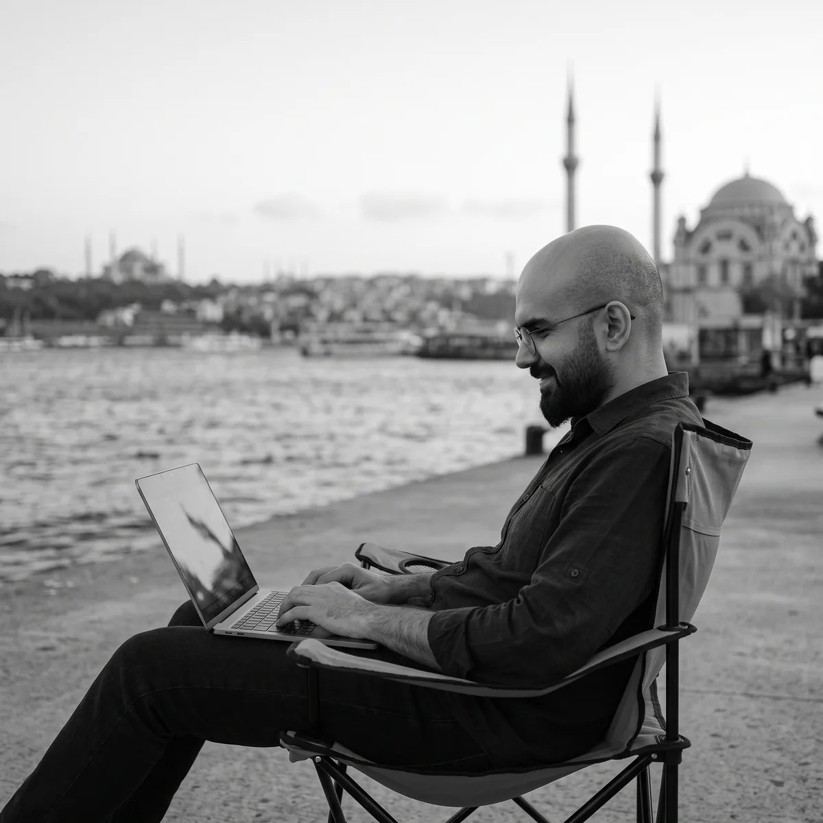Emin Savaş, İstanbul kıyısında bilgisayarıyla çalışırken. Yapay zekâ ile oluşturulmuş portre.